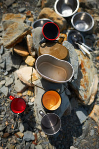 High angle view of empty coffee cups on rocks at campsite