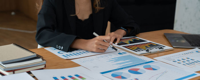 Midsection of business colleagues working on table
