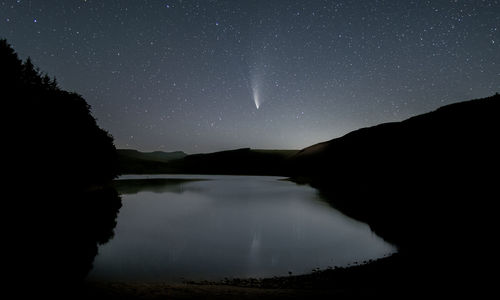 Scenic view of lake against sky at night