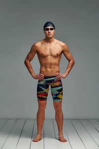 Shirtless man standing against white background