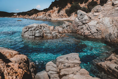 Rocks on sea shore against sky