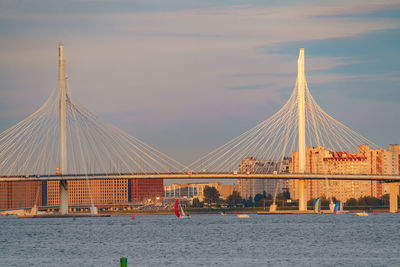 Low angle view of bridge over river against sky at sunset