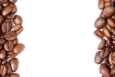 Directly above shot of roasted coffee beans against white background