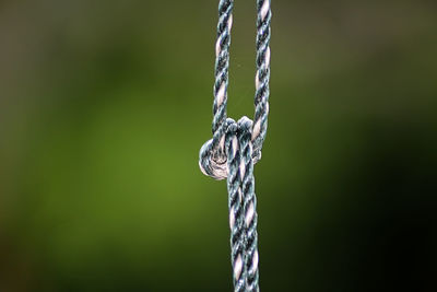 Close-up of rope tied up on metal chain