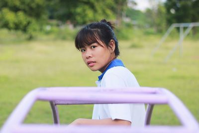 Portrait of young woman sitting in park