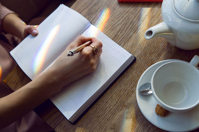 Girl in a pink dress sitting in a cafe at the table with a diary