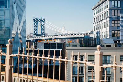 Manhattan bridge and empire state building against sky seen from city