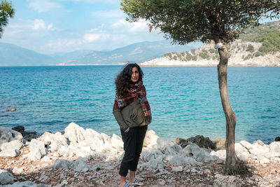 Portrait of young woman standing at beach