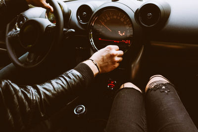 Cropped hands of man driving while traveling with woman in car