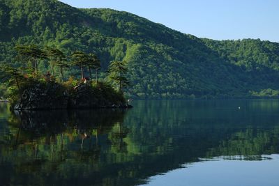 Scenic view of lake by trees against mountain