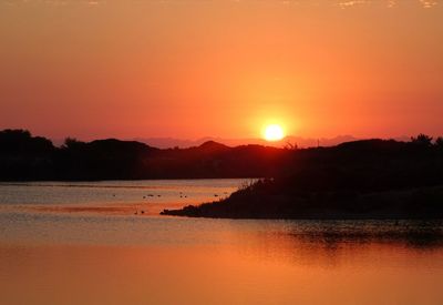 Scenic view of lake against romantic sky at sunset