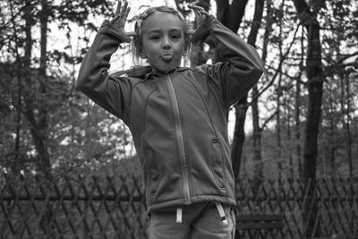 Portrait of girs jumping against tree