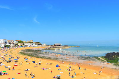 High angle view of people on beach against blue sky