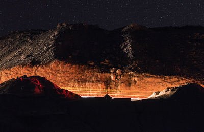 Panoramic view of illuminated mountain against sky at night