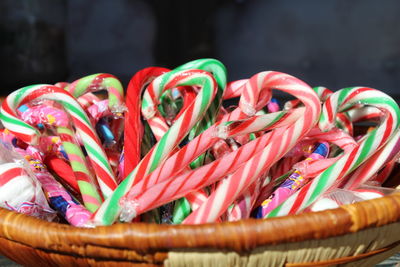 Close-up of multi colored candy canes in wicker basket