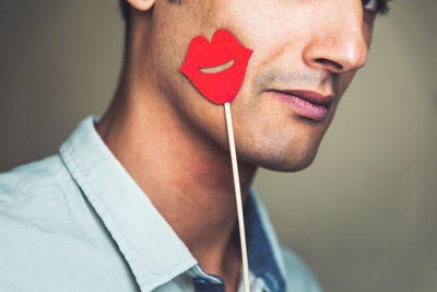 Midsection of man with prop against gray background