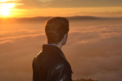 Man looking at view against cloudy sky during sunset