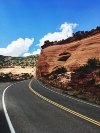 Road by mountain against sky