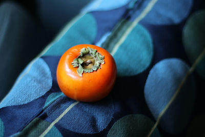 Close-up of persimmon on blue pillow 