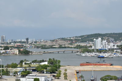 Cityscape by sea against sky