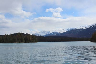 Scenic view of lake by snowcapped mountains against sky