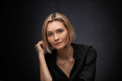 Portrait of a beautiful young woman over black background