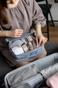 Midsection of woman packing bag