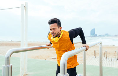 Young man exercising on railing