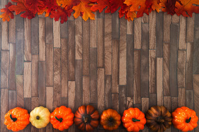 Orange pumpkins on wood with autumn leaves during halloween
