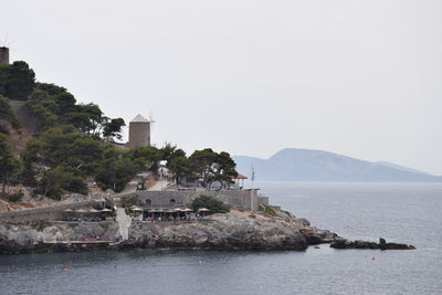 Scenic view of sea and buildings against clear sky