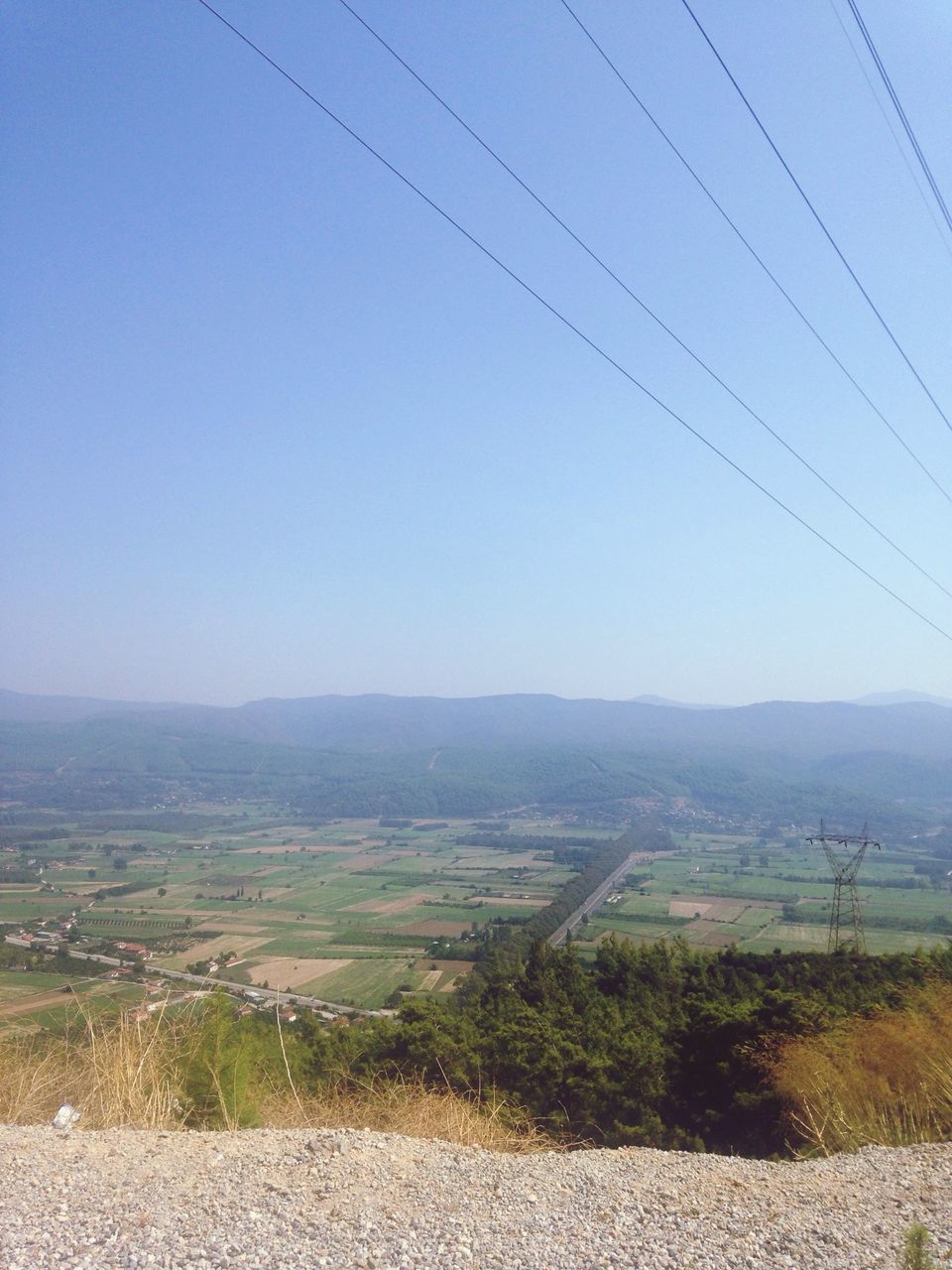 clear sky, landscape, tranquil scene, tranquility, power line, field, scenics, nature, copy space, electricity pylon, rural scene, horizon over land, beauty in nature, blue, sky, agriculture, cable, non-urban scene, remote, plant