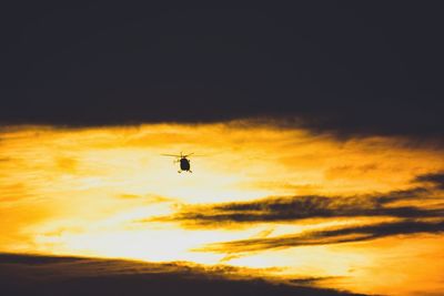 Low angle view of silhouette airplane against sky during sunset