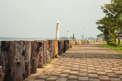 View of wooden footpath against clear sky