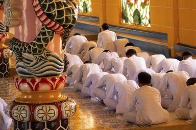 Rear view of men during praying in cao dai temple