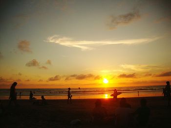 Silhouette of people at beach during sunset