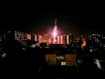 Illuminated cityscape against sky at night