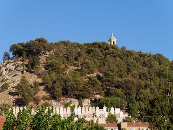 Castle on mountain against blue sky