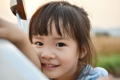 Portrait of girl leaning on car