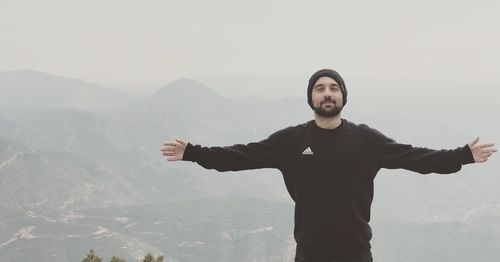 Full length of man standing on mountain against sky
