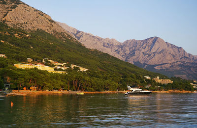 Scenic view of lake by mountains against sky