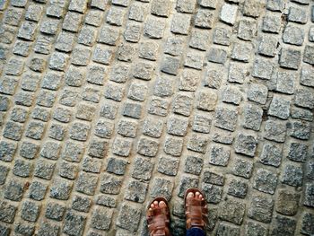 Low section of legs on cobblestone ground