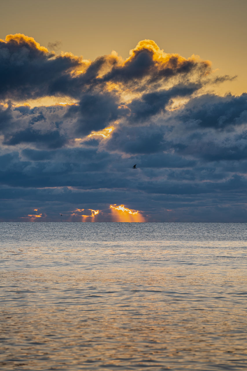 sky, sea, water, cloud, sunset, horizon, beauty in nature, scenics - nature, nature, ocean, dawn, sunlight, evening, tranquility, land, reflection, no people, tranquil scene, horizon over water, beach, wave, outdoors, orange color, coast, travel, idyllic, seascape, travel destinations, dramatic sky, sun, shore, afterglow, transportation, motion, environment, nautical vessel