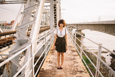 Full length of woman standing on footbridge