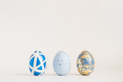 Three easter golden decorated eggs on white background. minimal easter concept. happy easter card 