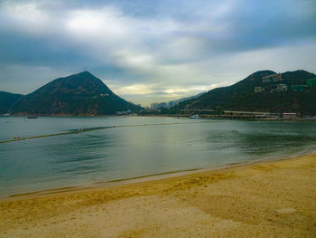 Scenic view of sea and mountains against sky