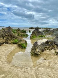 Rocks on beach against sky