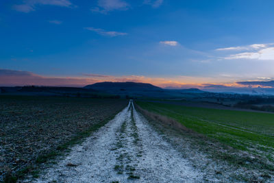 Scenic view of agricultural field against sky during sunset