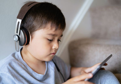 Portrait of boy using mobile phone at home