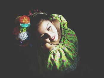 Young woman looking away against black background