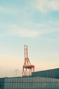Crane at construction site against sky
